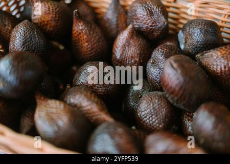 A bowl filled with fresh salak (snake fruit), highlighting its unique scaly skin and tropical appeal, ideal for exotic fruit or Indonesian food themes Stock Photo