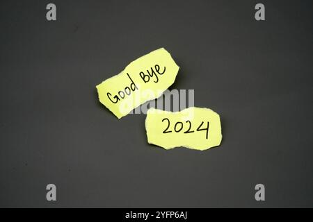 handwritten text "Good bye 2024" on a yellow torn paper Stock Photo