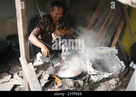 asian senior adult roasting coffee traditionally for sell at his shop Stock Photo