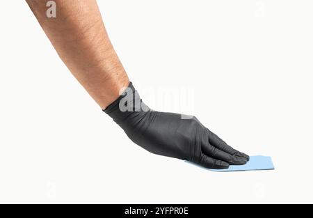 Hand with black glove wiping surface with gray microfiber rag isolated on white Stock Photo