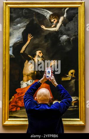 Man taking a photo of a painting with a cell phone in the Louvre museum, Paris, France Stock Photo