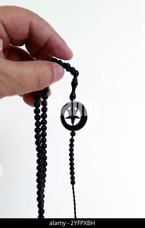 Muslim man praying with islamic beads in hand, religious meditation, worship. Ramadan concept. Stock Photo