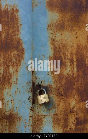 Rusty old metal doors are closed on a hinged lock. Cover. Stock Photo