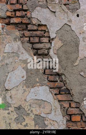 A strip of bricks in an old wall with destroyed plaster. For design. Stock Photo