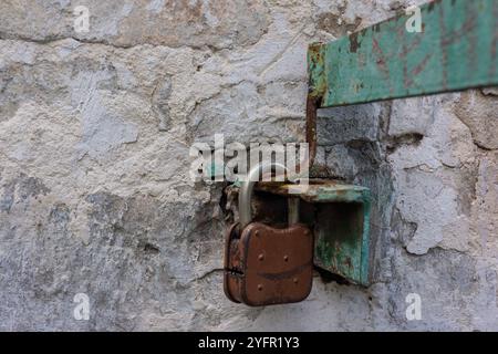 Old padlock on the fence on the wall. Web banner. Stock Photo