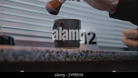 Murder or robbery case: Close up of unrecognizable criminalist searching fingerprints on cup belonging to victim using brush and magnetic powder. Forensic scientist works with evidence at crime scene. Stock Photo