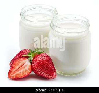 Two jars of homemade organic yoghurt and fresh strawberries near them on white background. Stock Photo