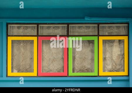 Background of colorful old windows in old town. Close up view of colorful windows with curtains. Travel photo, nobody Stock Photo
