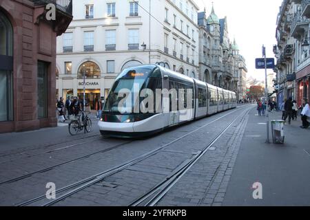 A city tram travels along Rue de la Mesange, a shopping street filled with tourists in Strasbourg, France, 2024 Stock Photo