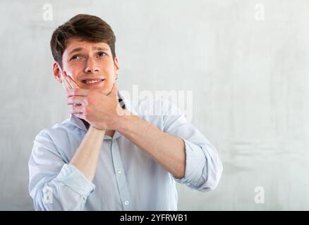 Young guy holding his cheek with toothache Stock Photo