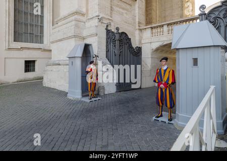 Pontifical Swiss Guards in one of the access doors to the Vatican City State, on the left side of St. Peter's Basilica Stock Photo