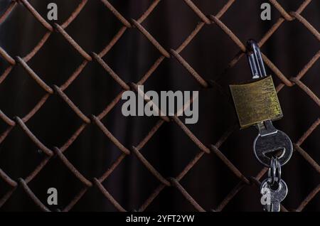 Chain link fence close up. Rusty steel mesh fence background. Texture of rusty metal wire. A perspective metal net wall with blur background. Stock Photo