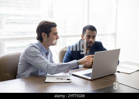 Two diverse male Internet project managers watching online startup Stock Photo