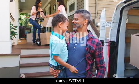 Family With Children Packing Boxes Into Van On Moving Day Stock Photo