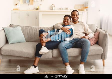 African american couple spending weekend together lying on sofa Stock Photo