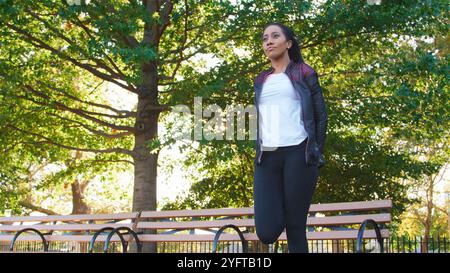 Woman Stretching And Warming Up Before Exercising Outdoors In Park Stock Photo
