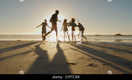 Group Of Casually Dressed Friends Having Fun On Summer Beach Together With Lens Flare Stock Photo