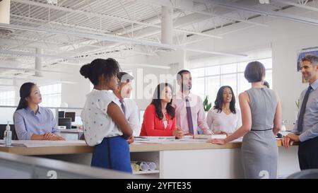 Multi-Cultural Business Team Meeting In Modern Open Plan Architects Office Together Stock Photo