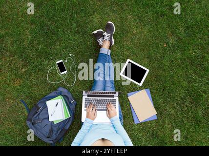 Girl with laptop sitting on the green grass Stock Photo