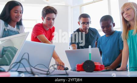 Students With Male Teacher In School Computer Coding Class Learn To Program Robot Vehicle Stock Photo