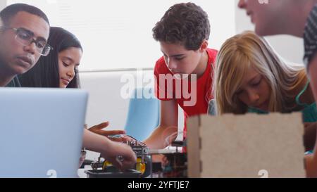 Students With Male Teacher In School Computer Coding Class Learn To Program Robot Vehicle Stock Photo