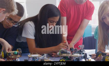 Students With Male Teacher In School Computer Coding Class Learn To Program Robot Vehicle Stock Photo