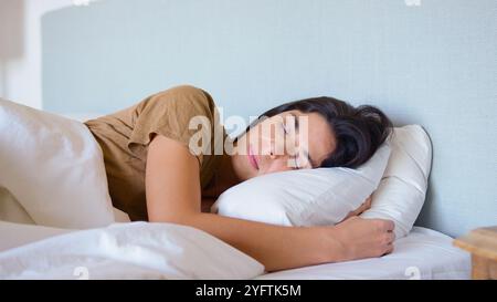 Close Up Of Peaceful Woman Asleep In Bed At Home Hugging Pillow Stock Photo