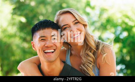 Couple enjoys a joyful moment together amid lush greenery. Stock Photo