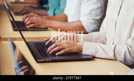 Close Up Of Multi-Cultural Business Team Typing On Laptop Computer Keyboard In Modern Office Stock Photo
