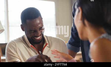 Close Up Of Multi-Cultural Business Team Meeting Around Desk In Modern Office Discussing Documents Stock Photo