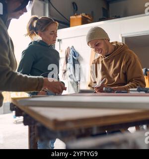 Male And Female Workers In Concrete Workshop Using Digital Tablet And Stylus Checking Samples Stock Photo