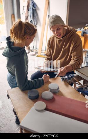 Male And Female Workers In Concrete Workshop Using Digital Tablet And Stylus Checking Samples Stock Photo