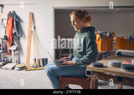 Female Worker In Concrete Workshop Using Laptop Computer Stock Photo