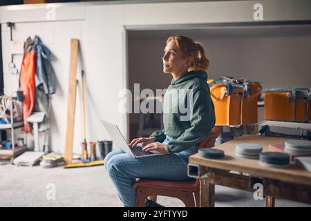 Female Worker In Concrete Workshop Using Laptop Computer Stock Photo