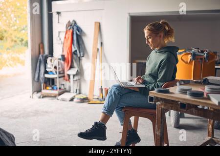 Female Worker In Concrete Workshop Using Laptop Computer Stock Photo