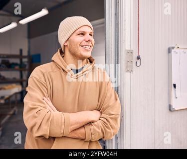 Portrait Of Smiling Male Worker Standing In Doorway Of Concrete Workshop Stock Photo