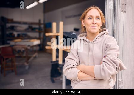 Portrait Of Female Worker Standing In Doorway Of Concrete Workshop Stock Photo