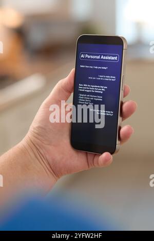 A person holds a smartphone displaying an AI personal assistant interface. The application showcases various suggestions and tasks that can be managed Stock Photo