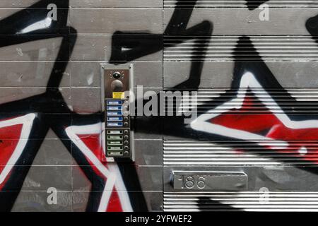 Street art covered door by a set of intercoms, Brick Lane, London, England Stock Photo