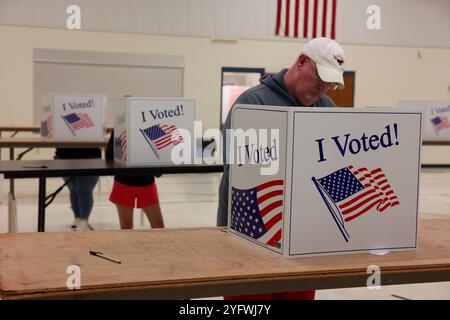 Bloomington, USA. 05th Nov, 2024. BLOOMINGTON, INDIANA - NOVEMBER 5: Voters cast their ballots in the gymnasium at St. John the Apostle Catholic Church on November 5, 2024 in Bloomington, Indiana. Americans vote today in the presidential race between Republican nominee former President Donald Trump and Democratic nominee Vice President Kamala Harris, as well as multiple state elections that will determine the balance of power in Congress. Credit: Jeremy Hogan/Alamy Live News Stock Photo