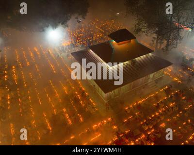 Narayanganj, Dhaka, Bangladesh. 5th Nov, 2024. Hundreds of Hindu devotees gather in front of Shri Shri Loknath Brahmachari Ashram temple for the Rakher Upobash, a religious fasting festival called ''Kartik Brati'' in Narayanganj, Bangladesh. Sitting in front of candle lights (locally named as Prodip), they fast and pray in earnest to the gods for their favours during the ritual. The festival is held on every Saturday and Tuesday in the last 15 days of the Bengali month Kartik. Worshippers keep fast from morning for this prayer and it means the last meal they had was their yesterday's dinner Stock Photo