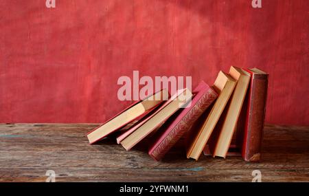 Row of red books on red grungy background, reading, learning, education or home office concept,free copy space. Stock Photo