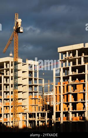 High-rise buildings under construction, featuring unfinished concrete and brick structures. While intense fighting continues in eastern Ukraine, the western regions are experiencing a construction boom. Cities in western Ukraine, such as Lviv, Ivano-Frankivsk, and Uzhhorod, have become hubs of active building and infrastructure development. These areas are attracting both internally displaced people and new investors, driving demand for housing, commercial real estate, and public facilities. The economic growth in the western regions contrasts sharply with the destruction and instability in th Stock Photo