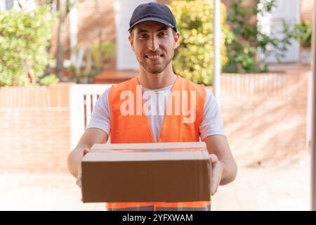 Delivery man delivering a package to the customer. Close-up of hands and cardboard box Stock Photo