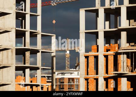 High-rise buildings under construction, featuring unfinished concrete and brick structures. While intense fighting continues in eastern Ukraine, the western regions are experiencing a construction boom. Cities in western Ukraine, such as Lviv, Ivano-Frankivsk, and Uzhhorod, have become hubs of active building and infrastructure development. These areas are attracting both internally displaced people and new investors, driving demand for housing, commercial real estate, and public facilities. The economic growth in the western regions contrasts sharply with the destruction and instability in th Stock Photo