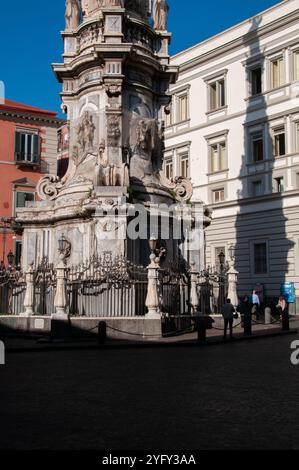 Spire of the Immaculate Conception in Piazza del Gesù with the projection of its shadow on the Genovesi high school. Naples Stock Photo