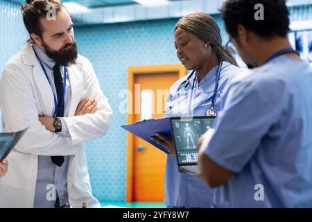 Healthcare team collaborates on human anatomy and diagnostic procedures. Group of specialists meeting in an office to discuss treatment plans after radiology test results. Disease prevention. Stock Photo