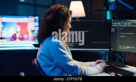 Teleworking system administrator futureproofing company network from downtimes and unexpected failures. Remote IT employee typing on keyboard, increasing data security, camera A Stock Photo