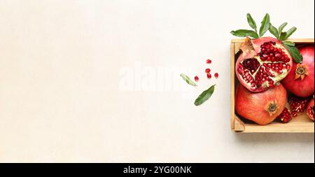 Ripe pomegranates in box on white background with space for text, top view Stock Photo