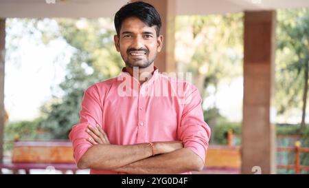 Confident young indian man wearing ethical dress standing cross arms against white background, Smiling handsome asian male with positive expression po Stock Photo